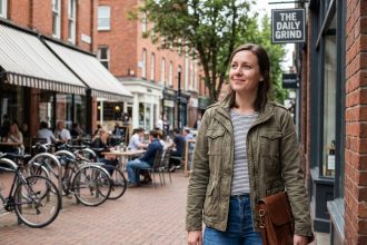 Femme souriante devant un café de ville en extérieur